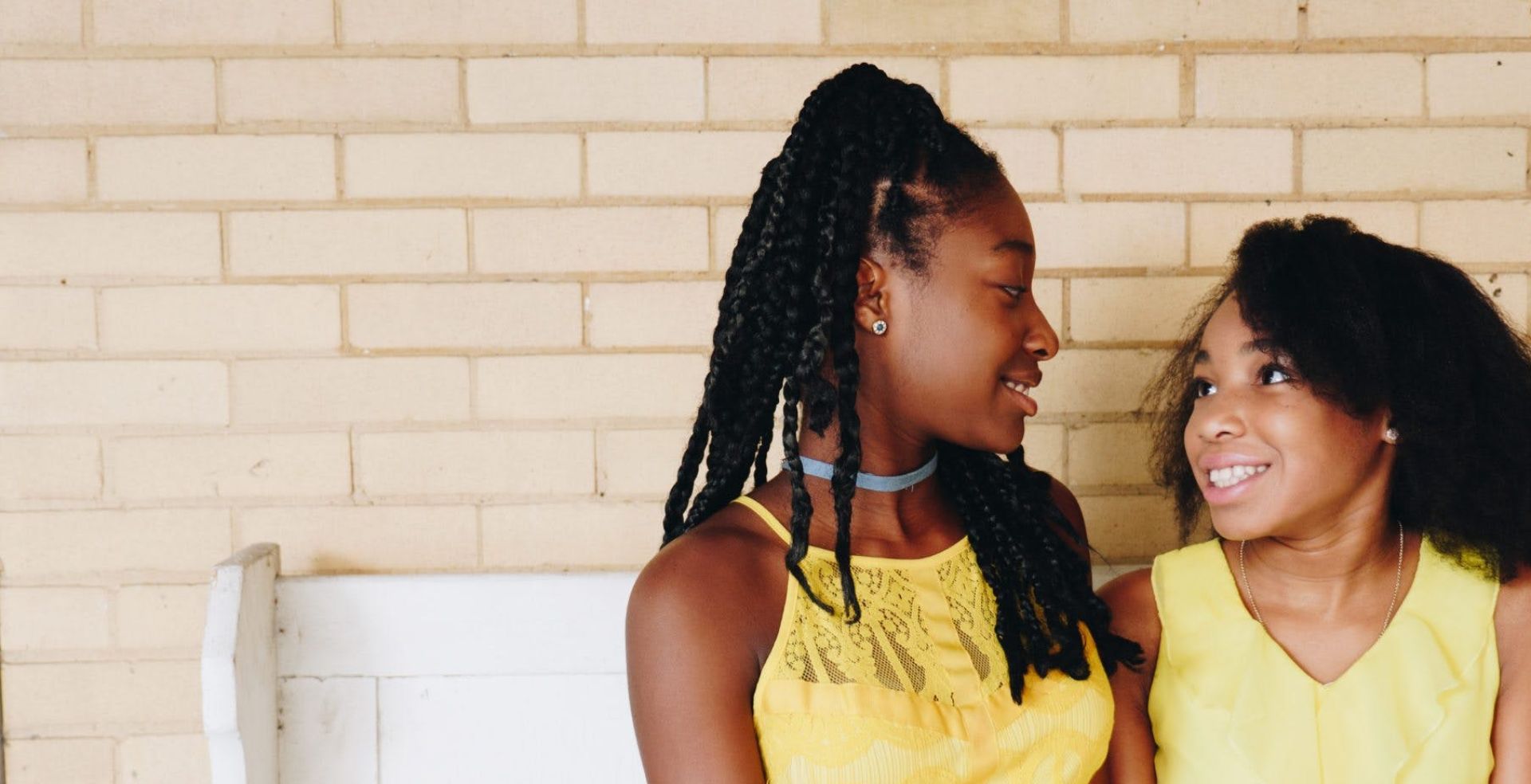 Two Girls Wearing Yellow Sleeveless Dresses