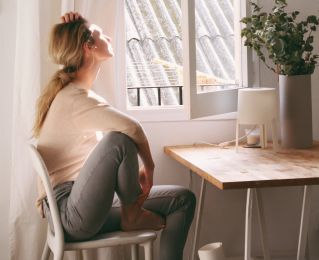 Woman Sitting on a Chair next to a Window